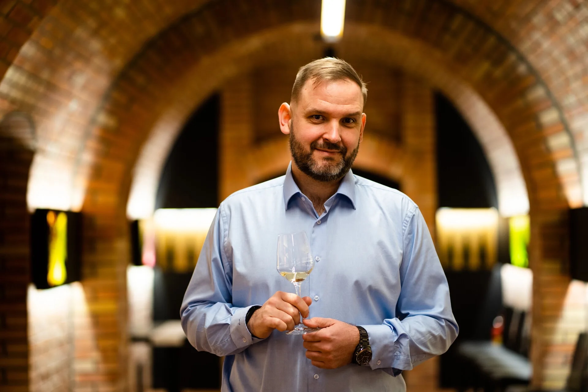 Petr Ptáček, director of Habánské sklepy, holding a glass in the cellar