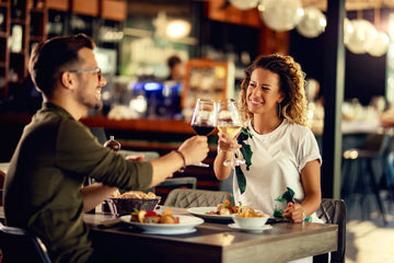 Couple enjoying a shared meal and conversation over glasses of wine in a restaurant setting